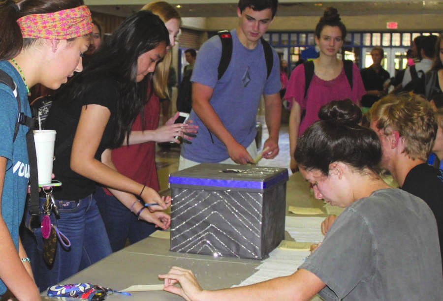 Gathering around the voting table, students cast their ballot for their favorite JCP candidate. 