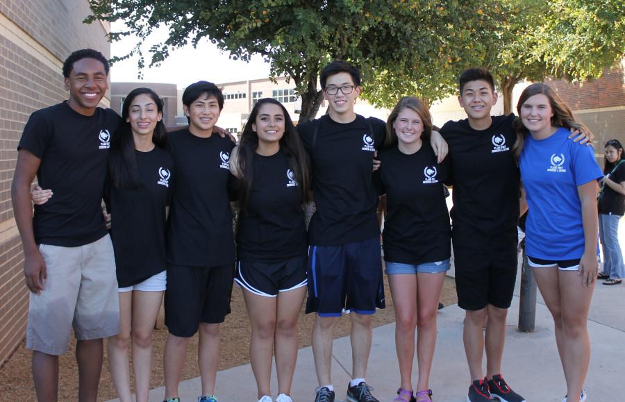 Beaming proudly for the camera, swim team members sport their team T-shirts.