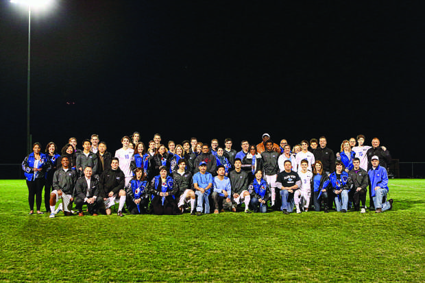 Gathering on the field, the boys soccer team celebrates their victory alongside their supportive parents.