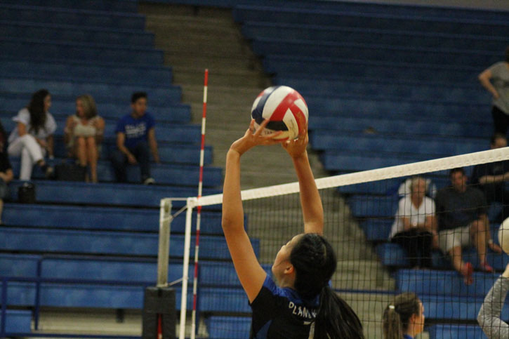 Junior varsity volleyball player Sydney Yap set the ball up for her teammate for a spike.