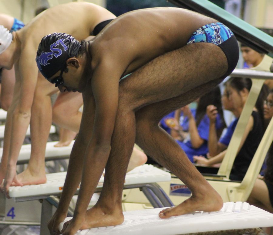Junior Varsity swimmer Vikran Ezhil mounts the starting block.