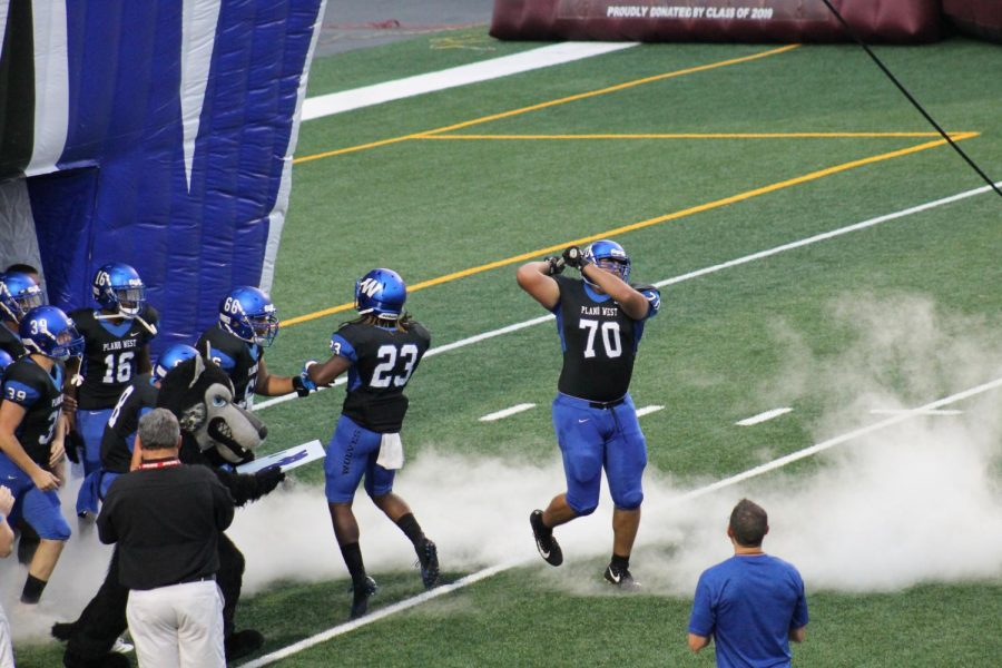 Offensive lineman Michael Balis (#70) drops the hammer to bring West out of the tunnel against Mesquite.
