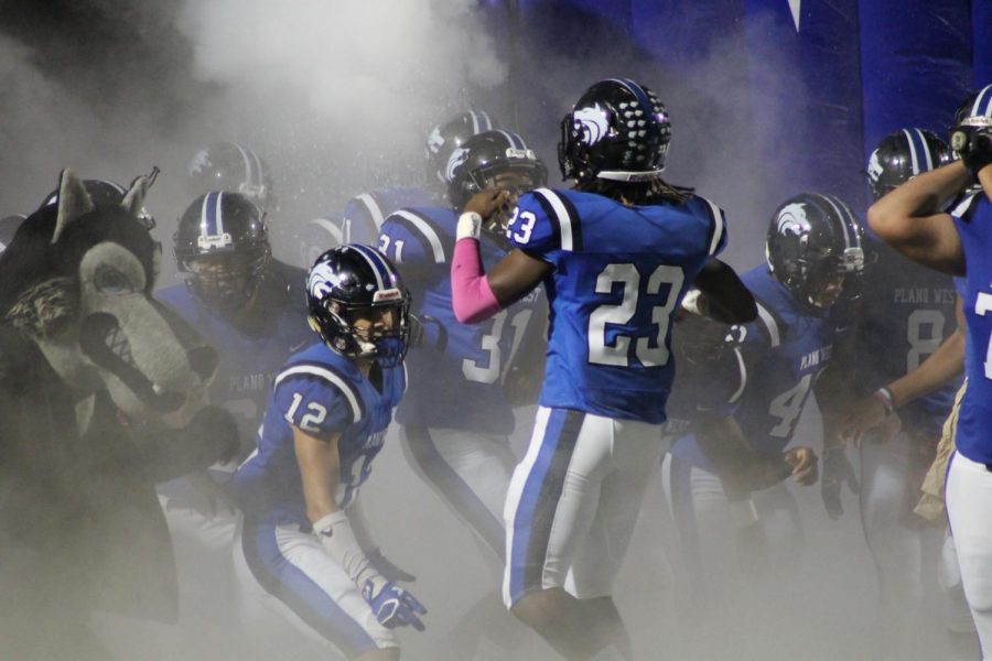 Wolves' linebacker Jared Brumfield (#23) leads Plano West out of the tunnel against McKinney on Friday.