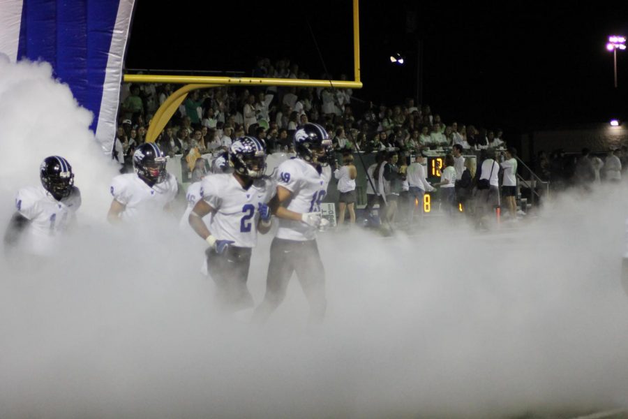 Plano West players Nick Griffin (#19) and Jacob Stephens (#2) run out of the tunnel.