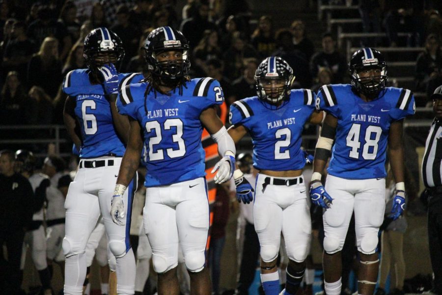 Wolves' defensemen Shemar Pearl (#6), Jared Brumfield (#23), Jacob Stephens (#2), and Tabron Yates (#48) look to the sideline for a playcall.