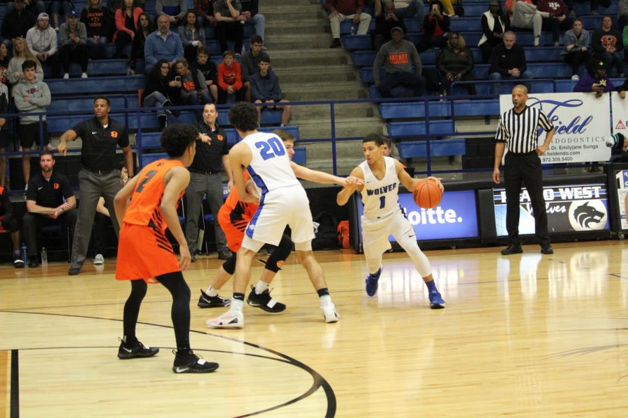 Wolves' point guard Daylen Minor (#1) dribbles the ball around a screen set by Alec Zambie (#20).