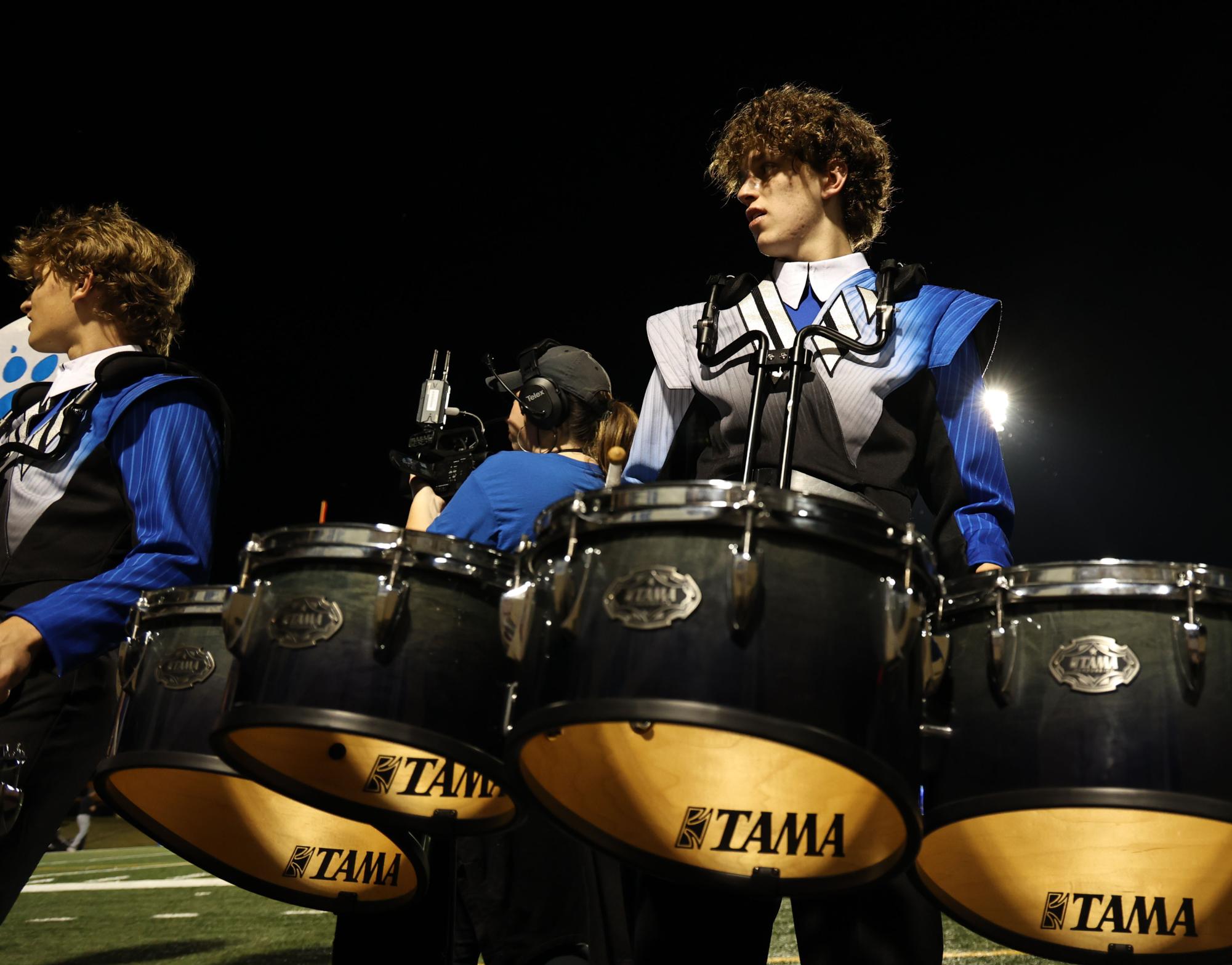 As the varsity football team takes on the Rock Hill High School hawks, junior Oliver Pringle waits for the signal to begin playing toward the student section while on the sideline Friday, Sept. 26. Each game, the drumline joins the cheerleaders to hype up the student section and cheer on the players.
