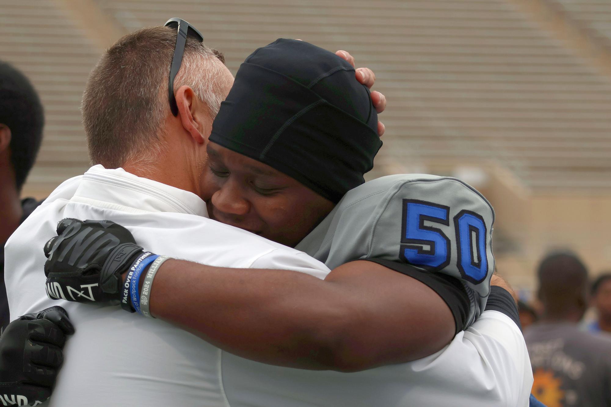 As senior football players run off the field, senior defensive lineman Kaleb Mills,#50, hugs defensive coordinator  Ty Gowerat, to show thanks after all he’s done for his this season at senior night Friday, Oct. 24. “Emotions were flying high because it was going to be our last home game,” Mills said. “I remember talking to Coach Gower and telling him how much he improved me and how much he taught me. It felt good to just give him a hug.”