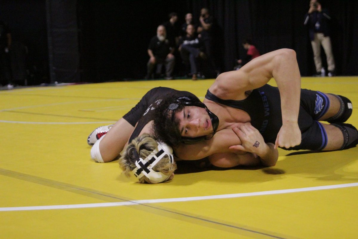 TAKE DOWN TO ADVANCE: To advance from the first round of the UIL state tournament, senior Ali Dodangeh rotates his opponent on his back during his dual Friday, Feb. 13, in Houston for the champtionship. In his seven years of wrestling, “I have a lot more accomplishments than just placing at state,” Dodangeh said. “My next goal is an Olympic title. As of right now, that’s what I’m looking for next.” 